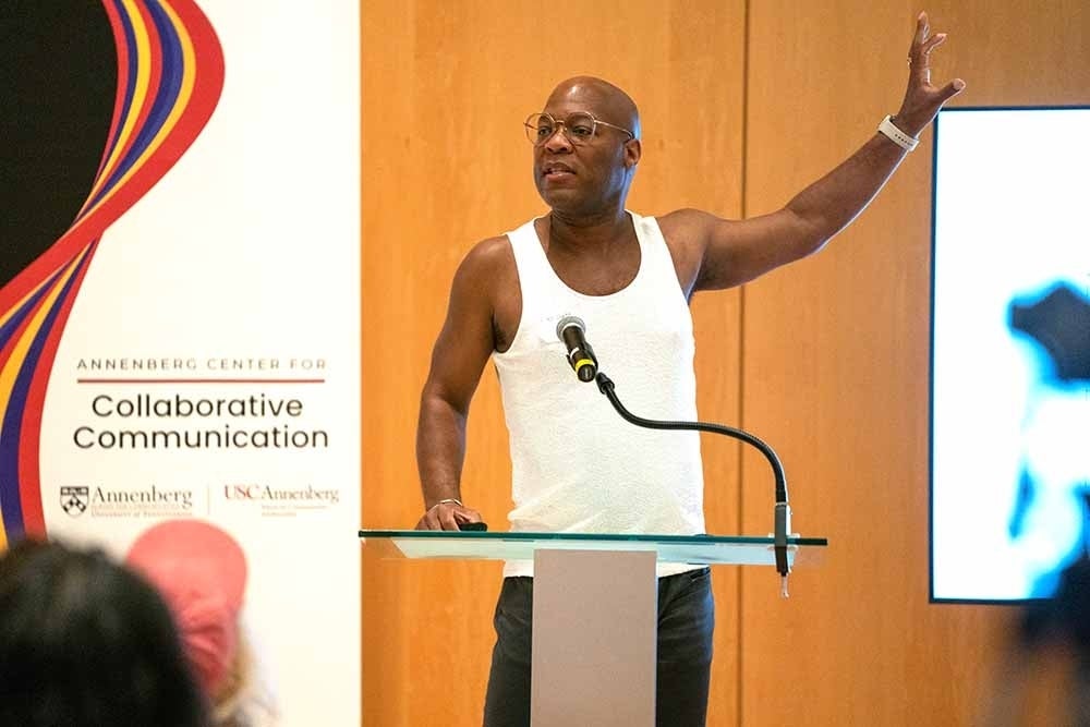 Alfred Martin Jr standing at a podium gesturing toward a screen