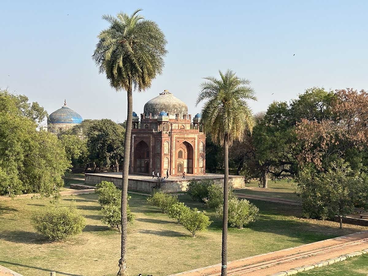 Humayun's Tomb viewed from a distance with palm trees in the foreground