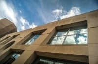 Photo of the Annenberg School building with clouds reflected in the window