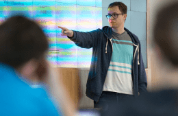 Alex Tolkin stands in front of classroom screen