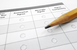 A paper survey with columns reading "Somewhat Agree" "Strongly Agree" and "Agree Completely" and bubbles to be filled in. A pencil is placed on the paper.