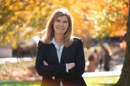 Sarah Banet-Weiser standing outside in front of a tree with fall colors