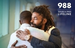 An image of two men embracing next to text reading "988 Suicide and Crises Lifeline"