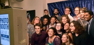 Large group of students posing against a background in a photo booth