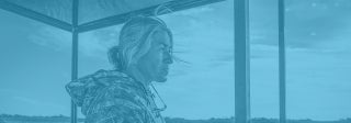 Woman standing on a boat and looking out over a swamp, photo credit Grant Bemis