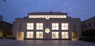 Locust Walk-side facade of the Annenberg School building, lit up from the inside at night