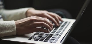 Hands typing on a keyboard, Credit to Kaitlyn Baker / Unsplash