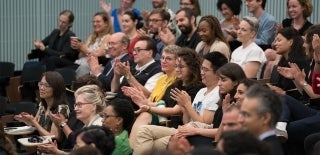 Audience clapping at a lecture