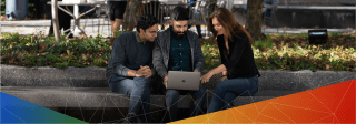 Photo of three lab members looking at something on a laptop together