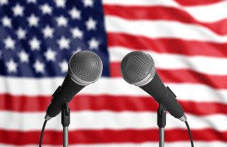 decorative image of two microphones in front of an American flag