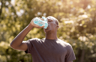 A man drinks water on a hot summer day