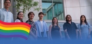 Andy Tan with students and an LGBTQ flag