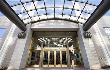 Front doors of Federal Communications Commission with glass awning overhead. Photo Credit: Marc Van Scyoc / Shutterstock