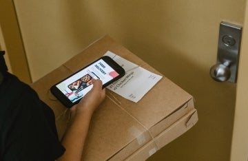 Photo featuring boxed pizza delivered to the door