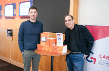 Lee McGuigan and Professor Joseph Turow pose in front of McGuigan's book