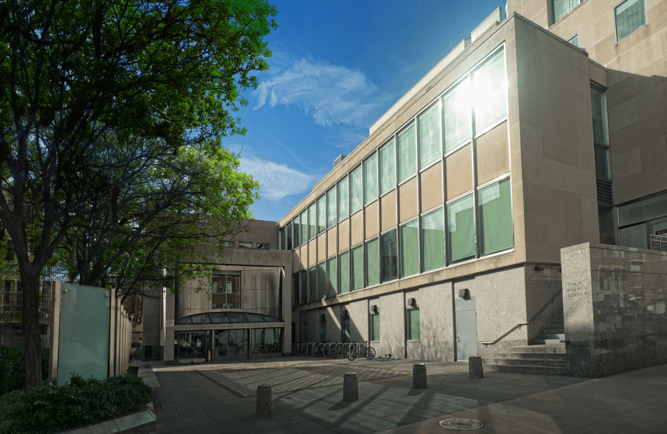 Walnut Street entrance to Annenberg School, a brown building with green transparent windows