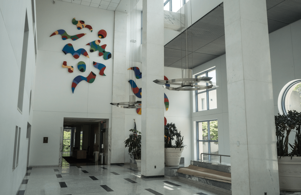 white room with colorful abstract art on top side of the wall, above the entrance 