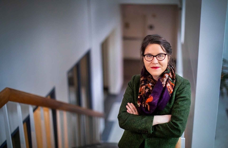 Muira McCammon standing on a staircase with her arms folded, photo credit Eric Sucar