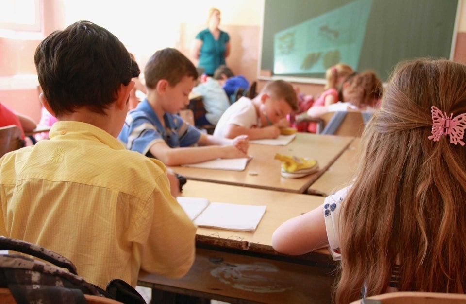 Students sitting and working in a classroom, photo credit Megan Soule / Unsplash