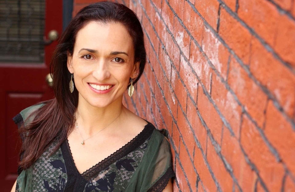 Sandra Gonzalez-Bailon poses for portrait next to brick wall