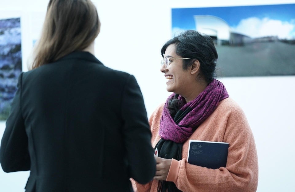 Roopa Vasudevan chats with fellow graduate student at event