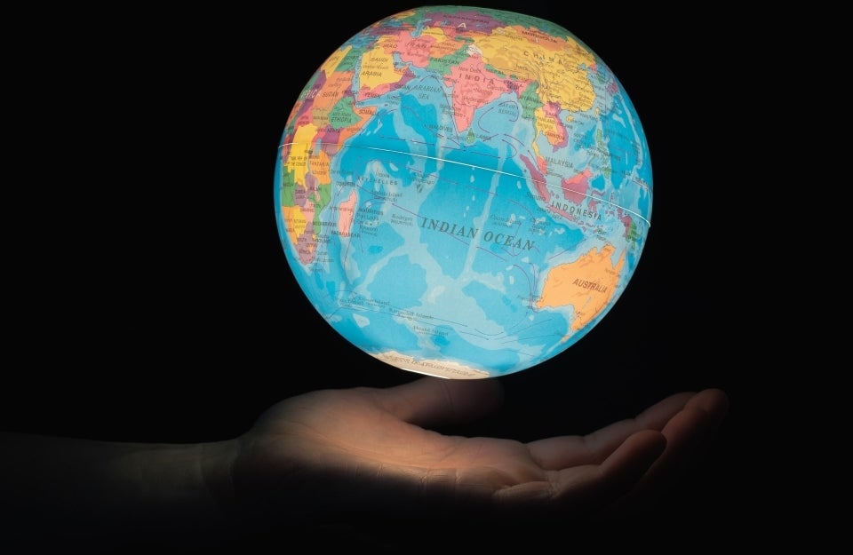 hand holding glowing globe in the dark, photo credit Greg Rosenke / Unsplash