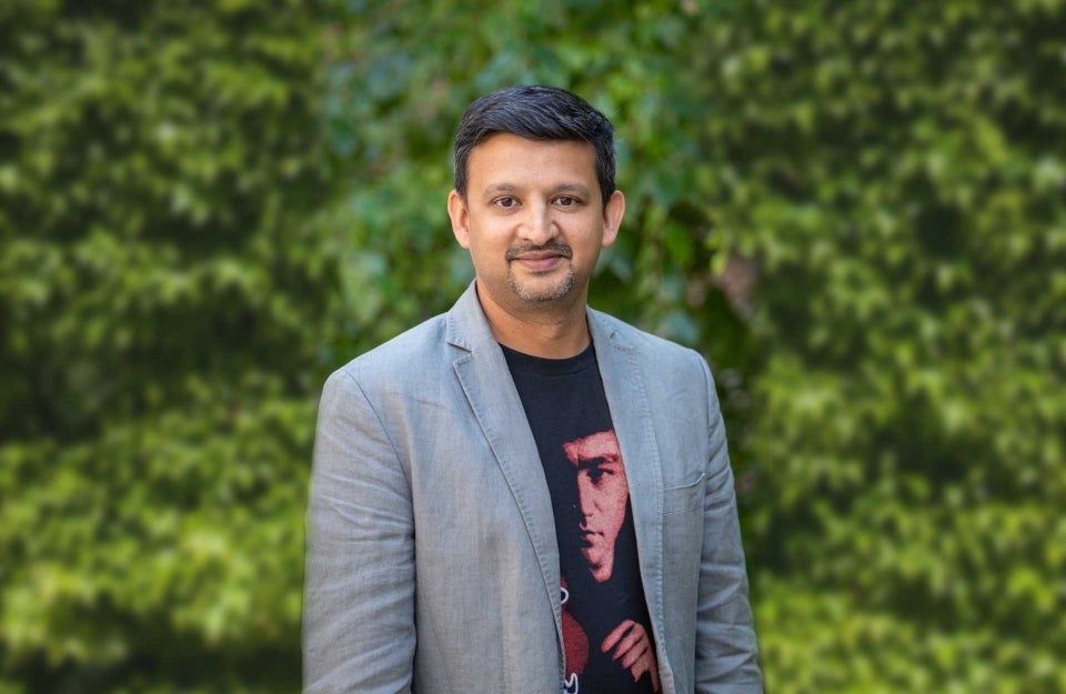 Aswin Punathambekar standing in front of some ivy