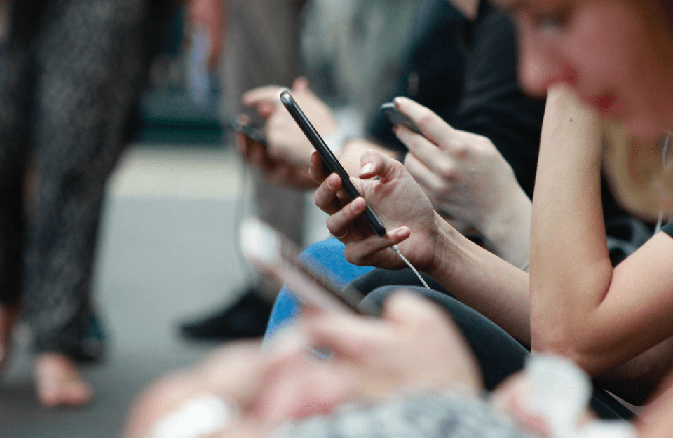 People holding phones while sitting