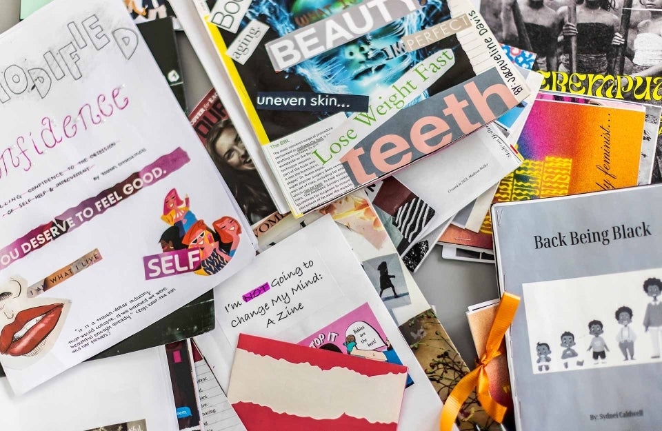 A pile of zines read things like, "uneven skin...," "lose weight fast," and "I'm not going to change my mind."