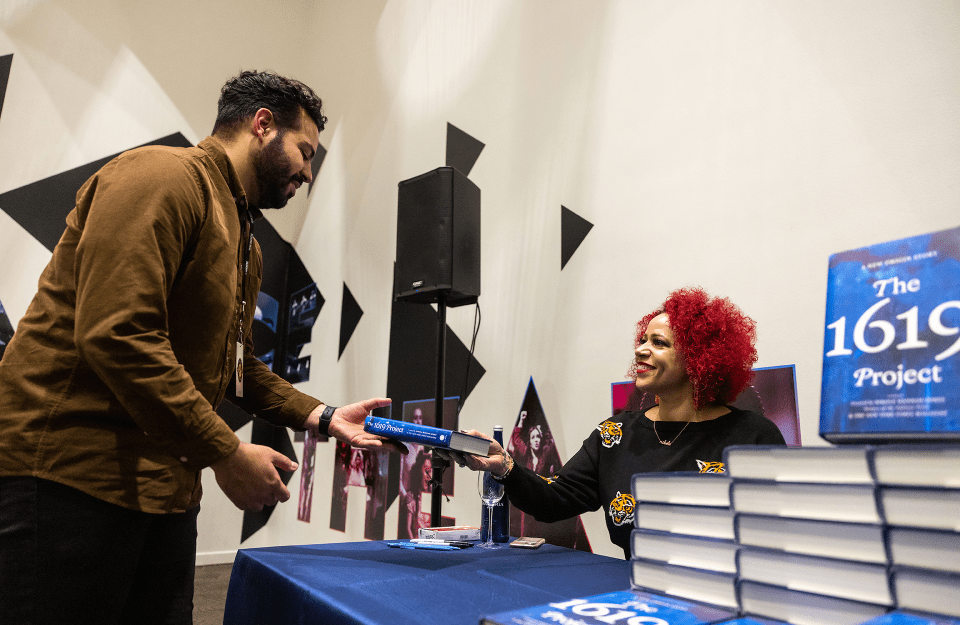 Nikole Hannah-Jones hands a "The 1619 Project" book to a lecture attendee