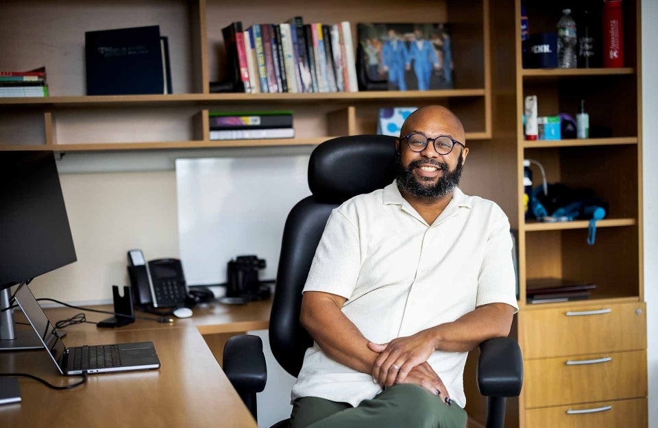 Desmond Patton seated at a desk in an office