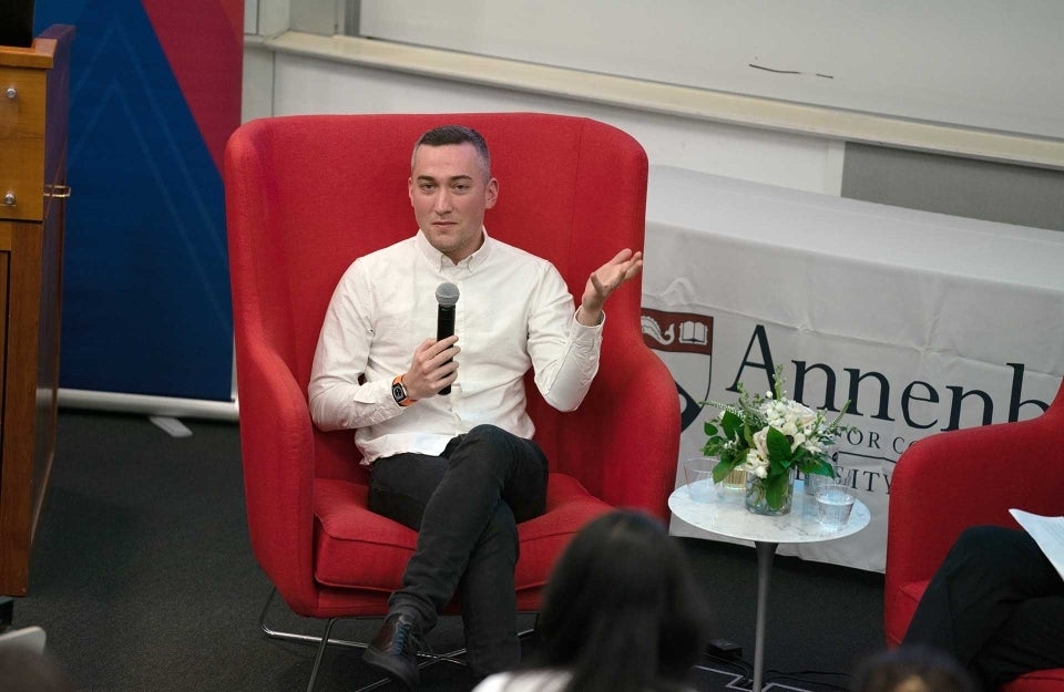 Yoel Roth seated in a red chair speaking into a microphone