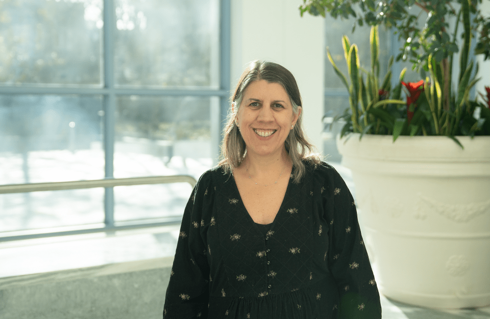 Susan Lape Roberts (MAC ‘99) stands in front of a window