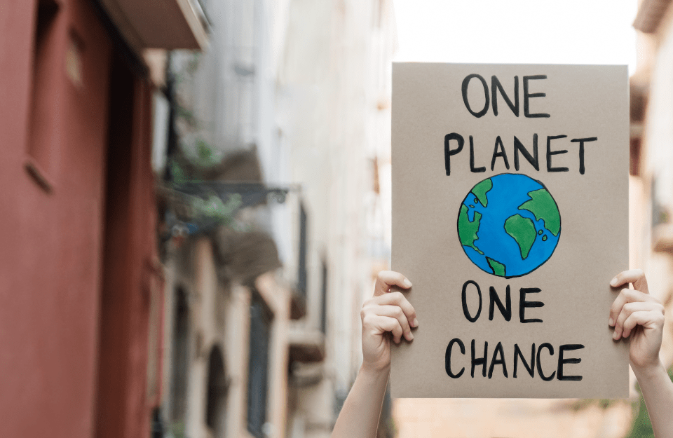 Hands holding a "One Planet One Chance" poster