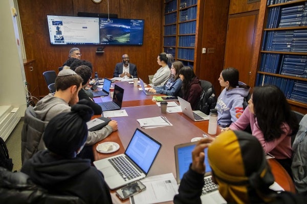 Dean Jackson and Amit Das at the head of a table with students seated around it