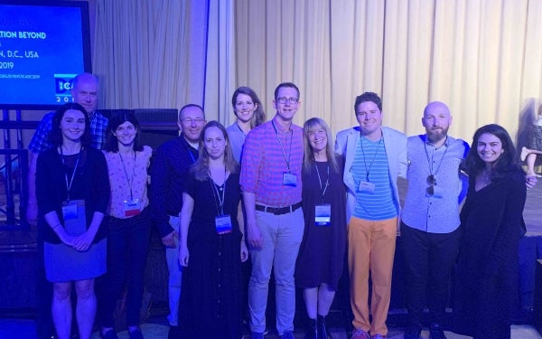 Group of people standing in front of a curtain