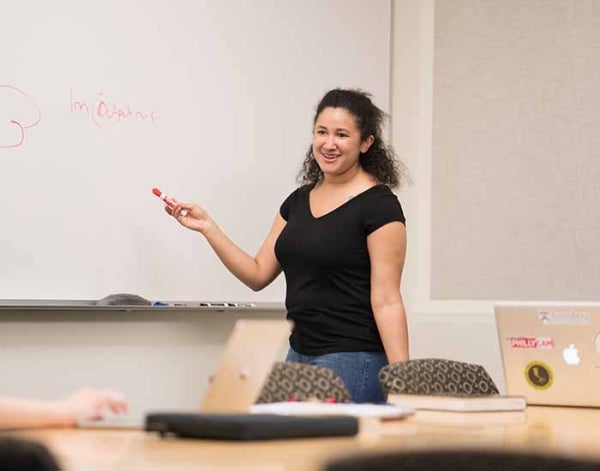 Mary Andrews standing in front of a white board, talking and holding a marker