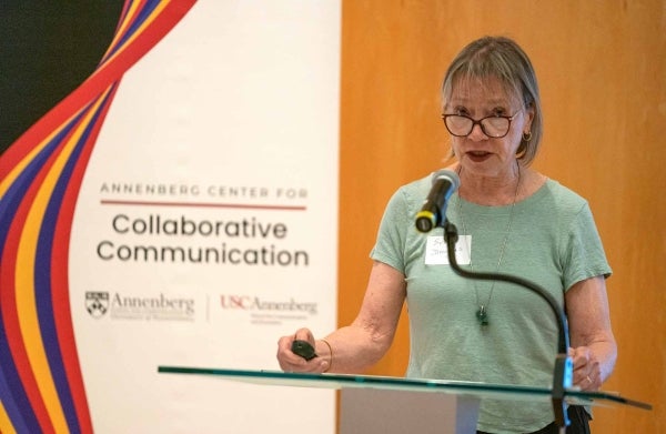 Susan Douglas speaking at a podium with an Annenberg Center for Collaborative Communication banner behind her