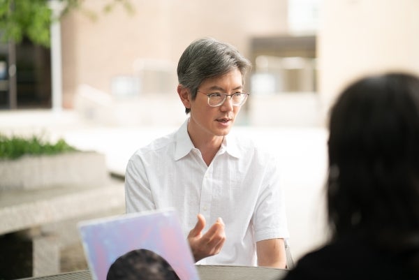 Andy Tan sits at a table outside