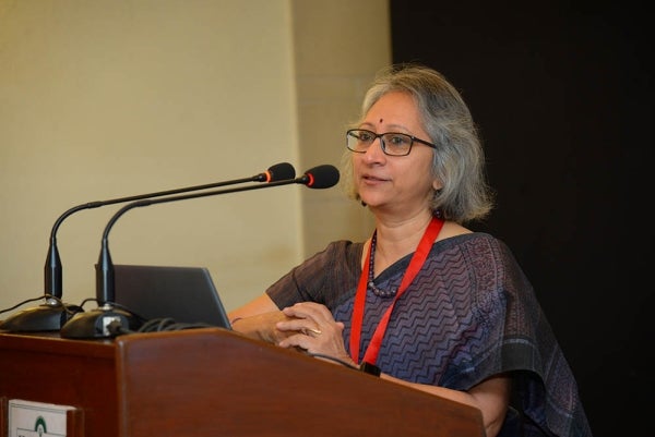 Usha Raman speaking at a podium