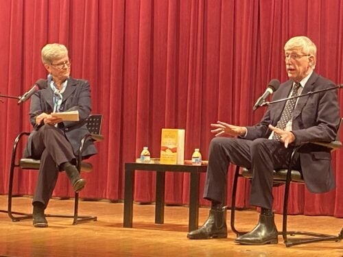 Kathleen Hall Jamieson and Francis Collins sit in chairs on a stage having a discussion