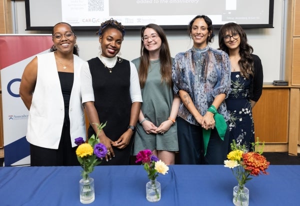 Azsaneé Truss, Cienna Davis, Valentina Proust, Lucila Rozas Urrunaga, Sim Gill stand at the front of a lecture hall