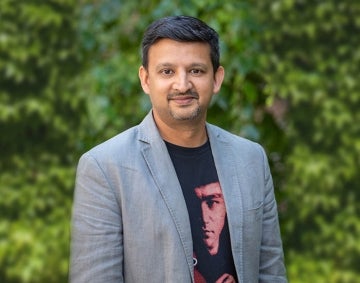 Aswin Punathambekar standing in front of some ivy